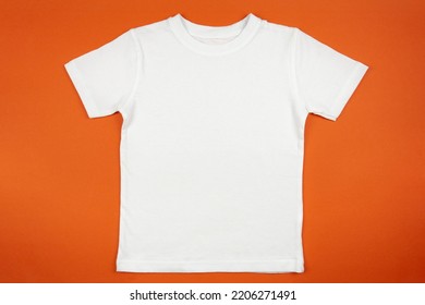 White Womens Cotton Tshirt Mockup On Orange Background. Design T Shirt Template, Print Presentation Mock Up. Top View Flat Lay. 