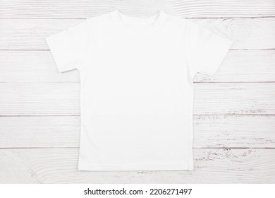 White Womens Cotton Tshirt Mockup On Wooden Background. Design T Shirt Template, Print Presentation Mock Up. Top View Flat Lay. 