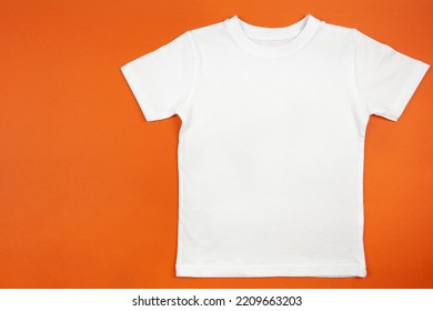 White Womens Cotton Tshirt Mockup On Orange Background. Design T Shirt Template, Print Presentation Mock Up. Top View Flat Lay. 