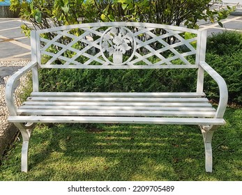 White Wood Bench Chair With Bush Background In Garden

