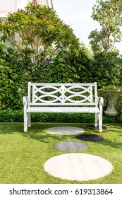 White Wood Bench Chair With Bush Background In Garden At Home.