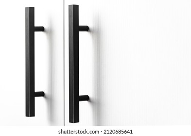 white wood cupboard door by black handle. Modern kitchen furniture concept. Cozy apartment details. Closet usage