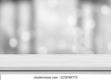 White Wood Tabletop Over Blur White Bokeh Light Background. Empty Wooden Counter, Shelf For Product Display, Banner Or Mockup.