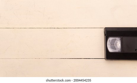 White Wooden Background With An Old Black Vhs Tape On One Side