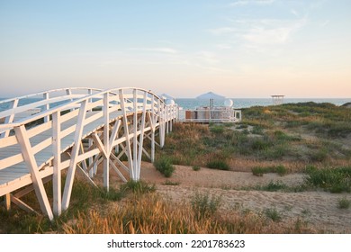 White Wooden Bridge On The Beach At Sunset