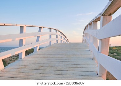 White Wooden Bridge On The Beach At Sunset