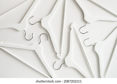 White wooden clothes hangers and coat hangers on a white background.
				Sale and shopping concept.