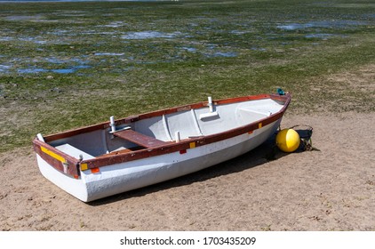 White Wooden Dinghy And A Yellow Float