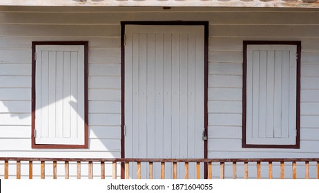 White wooden door and windows with porch railing made from recycled old wood panels, reuse concept