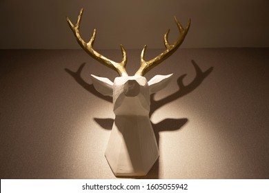 White Wooden Fake Taxidermy Deer Placed Against The Wall With Studio Lighting