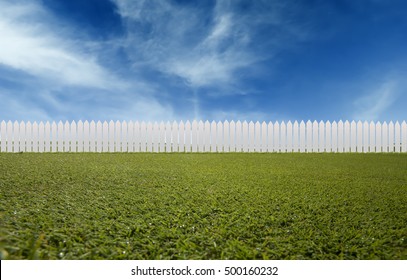 White wooden fences and green grass low angle