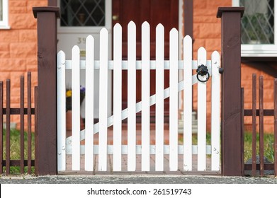 white wooden gate and low fence around a garden