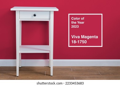 White wooden nightstand table against magenta wall. Color of the year 2023, viva magenta. - Shutterstock ID 2233453683