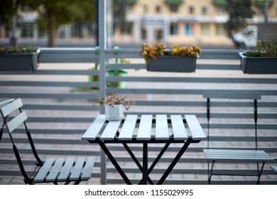 White Wooden Planks Table, Chairs And Horizontal Fence Of Cafe In The Street. Background For Product Placement. Isolated Outdoor Empty European Restaurant Or Coffee Shop Exterior. No People.