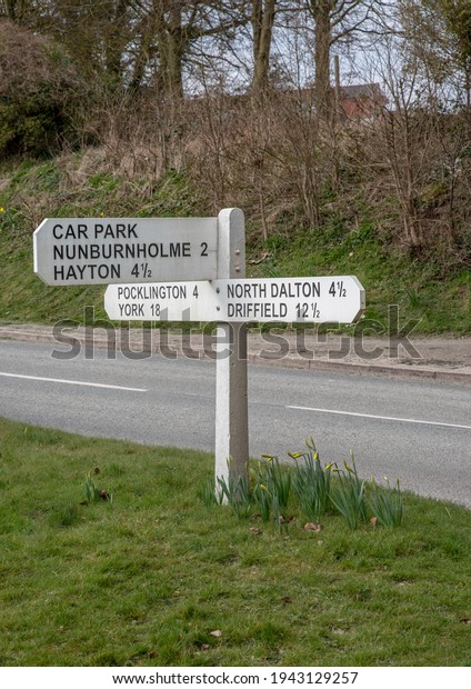 A white wooden signpost with directions to
a car park and six towns in
yorkshire.