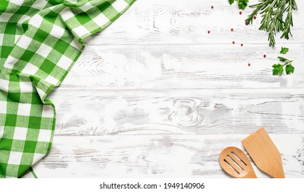 White wooden table covered with green tablecloth and cooking utensils. View from top. Empty tablecloth for product montage. Free space for your text	 - Shutterstock ID 1949140906