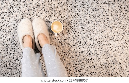 Ropa blanca de lana en pies de mujer adulta blanca, alfombra y café interior escena diaria, estilo de vida de temporada invernal