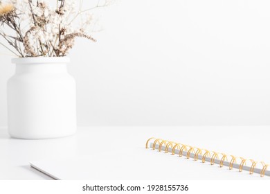 White Work Office Desk, Open Notebook With Spiral, Dried Flowers In Vase On White Table. Place For Text, Copy Space, Mockup