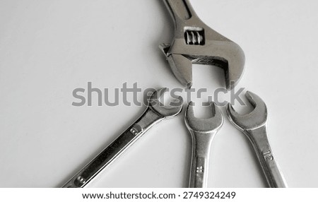 White Work Table Surface With Set of Open End Wrenches Under One Adjustable Spanner
