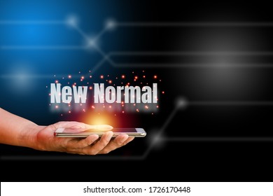 White World New Normal On Hand Holding Smartphone With Orange Light On Blue And Black Technology Background. New Normal Concept.