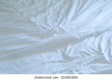 White Wrinkled Bedding Sheet Was Taken In Hotel Room With Copy Space. Blanket Background Texture