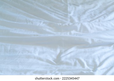 White Wrinkled Bedding Sheet Was Taken In Hotel Room With Copy Space. Blanket Background Texture