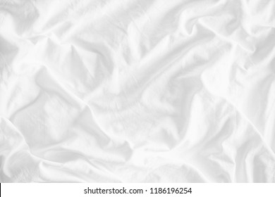 White wrinkled fabic texture rippled surface,Close up unmade bed sheet in the bedroom after night sleep Soft focus.