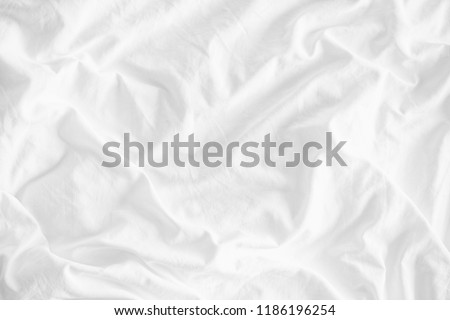 White wrinkled fabic texture rippled surface,Close up unmade bed sheet in the bedroom after night sleep Soft focus.