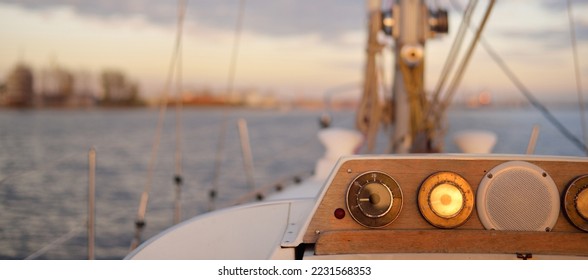 White yacht arriving in port at sunset. Close-up view from the deck to the bow and sails. Dramatic sky after the storm. Baltic sea. Nautical vessel, transportation, service, sport, recreation concepts - Powered by Shutterstock
