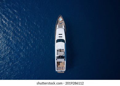 White Yacht Open Sea Aerial View. Super Yacht On Blue Water Top View. A Huge White Super Mega Yacht On Blue Water In Italy.