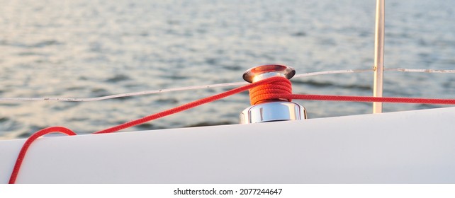 White yacht sailing after the storm. Boat side railing, mast winch, red rope close-up. 32 feet swedish built cruising sailboat. Mälaren lake, Sweden. Cruise, recreation, sport, leisure activity