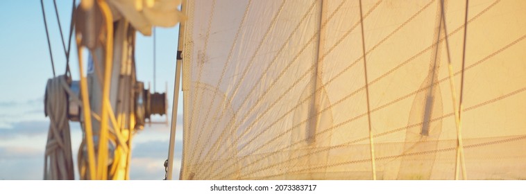 White yacht sailing in Daugava river at sunset. Close-up view from the deck to the bow, mast and sails.  Riga bay, Latvia - Powered by Shutterstock