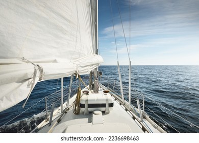 White yacht sailing in the North sea after the storm. Norway. Close-up view of deck, mast, sails. Clear blue sky, soft sunlight. Transportation, cruise, recreation, regatta, sport, leisure activity - Powered by Shutterstock