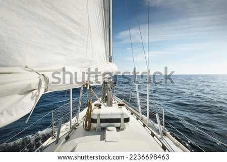 White yacht sailing in the North sea after the storm. Norway. Close-up view of deck, mast, sails. Clear blue sky, soft sunlight. Transportation, cruise, recreation, regatta, sport, leisure activity