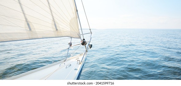 White yacht sailing on a sunny summer day. Top down view from the deck to the bow, mast and sails. Waves and water splashes. Clear blue sky. Gulf of Finland - Shutterstock ID 2041599716