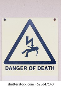 A White Yellow And Black Close Up Sign On The Wall Saying Danger Of Death With Electric Bolt And Dead Man In Triangle Safety Warning Electrics Electrified Uk England Us Grid