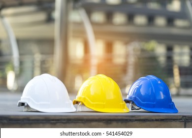 White, Yellow And Blue Hard Safety Helmet Hat For Safety Project Of Workman As Engineer Or Worker On Floor