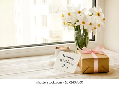 White Yellow Daffodil, Narcissus Flowers In Glass Vase On Wooden Windowsill, No Window Wiev. Happy Mother's Day Text Greeting Card And Craft Paper Prsent. Close Up, Copy Space, Still Life, Background.