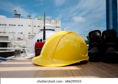 White And Yellow Hard Safety Helmet Hat In Industrial Plant On Blue Sky Background