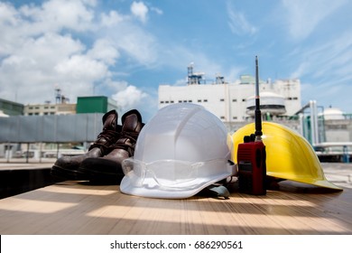 White And Yellow Hard Safety Helmet Hat In Industrial Plant On Blue Sky Background