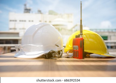 White And Yellow Hard Safety Helmet Hat In Industrial Plant On Blue Sky Background