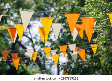 white, yellow and orange triangle flags hang on white rope in garden view. concept : fun party. - Shutterstock ID 2147989211