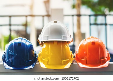 White, yellow and other colored safety helmets for workers' safety projects in the position of engineers or workers on concrete walls in the city.