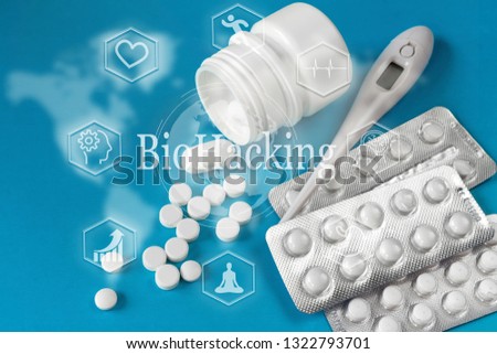 White and yellowWhite  round pills are poured against a blue white plastic pill background. view from above. drug. concept of biohacking