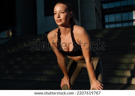 White young blond woman wearing sports bra doing workout in sunlight outdoors