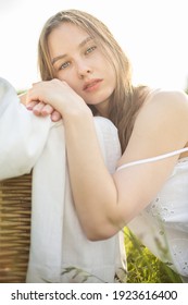 White young girl in white dress outside snuggling to the sheets