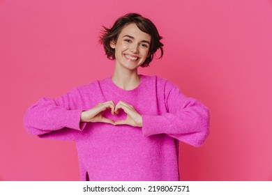 White young woman smiling and making heart gesture isolated over pink background - Shutterstock ID 2198067571