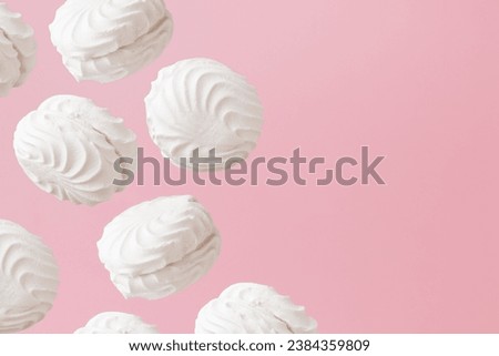 White zephyr marshmallows on light pastel pink background banner with an empty space.