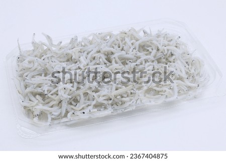 Whitebait in plastic container on white background