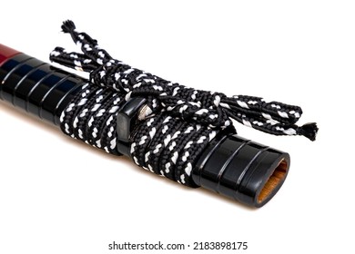 White-Black 'Sageo': silk cord for tying. Shining black Japanese scabbard isolated on a white background. Selective focus.